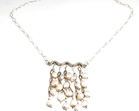 Mini Coin fresh water pearls hanging in a cluster from a sterling silver bar and chain.