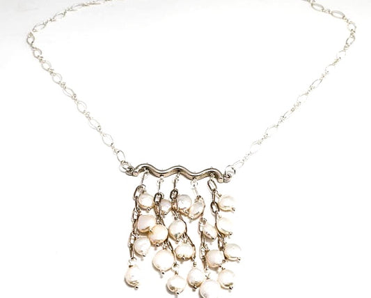 Mini Coin fresh water pearls hanging in a cluster from a sterling silver bar and chain.
