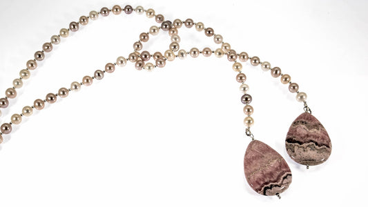 Fresh water pearls in peaches and cream colours lariat that ties in front and has two tear drop shaped Rhodocrosite stones as anchors.