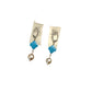 Pair of earrings with blue and pearl-like stones on a white background