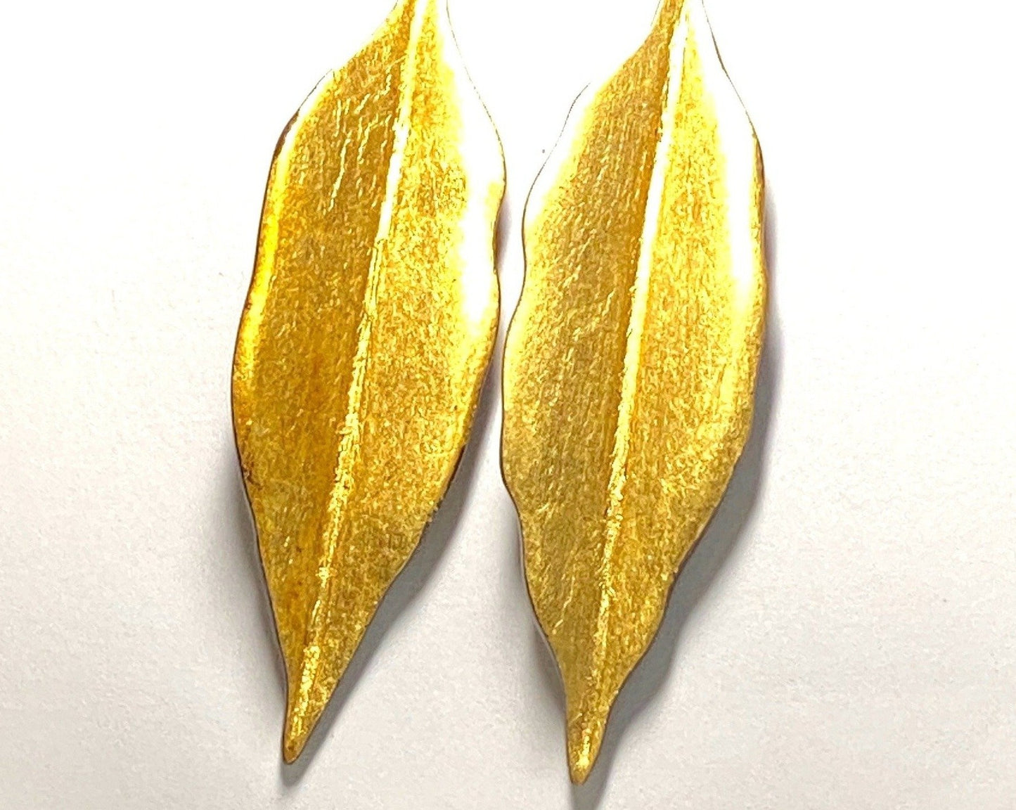 Ebony wood, gold leaf and sterling silver earrings in the shape of a leaf. About 3 inches long.