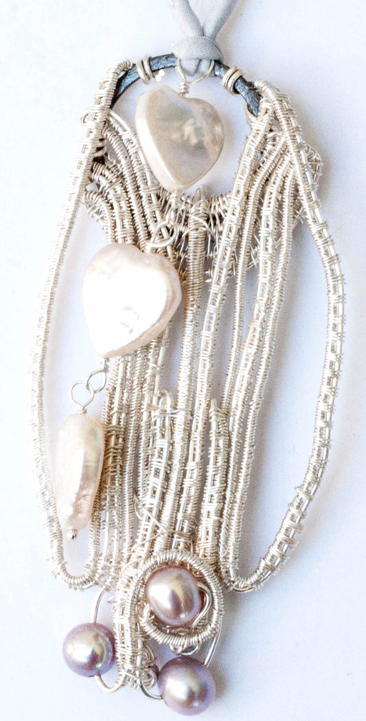 Fresh water pearls with woven fine silver with three heart shaped pearls dangling in front.