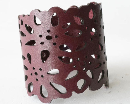 Two inch wide leather cuff laser cut with a flower design.